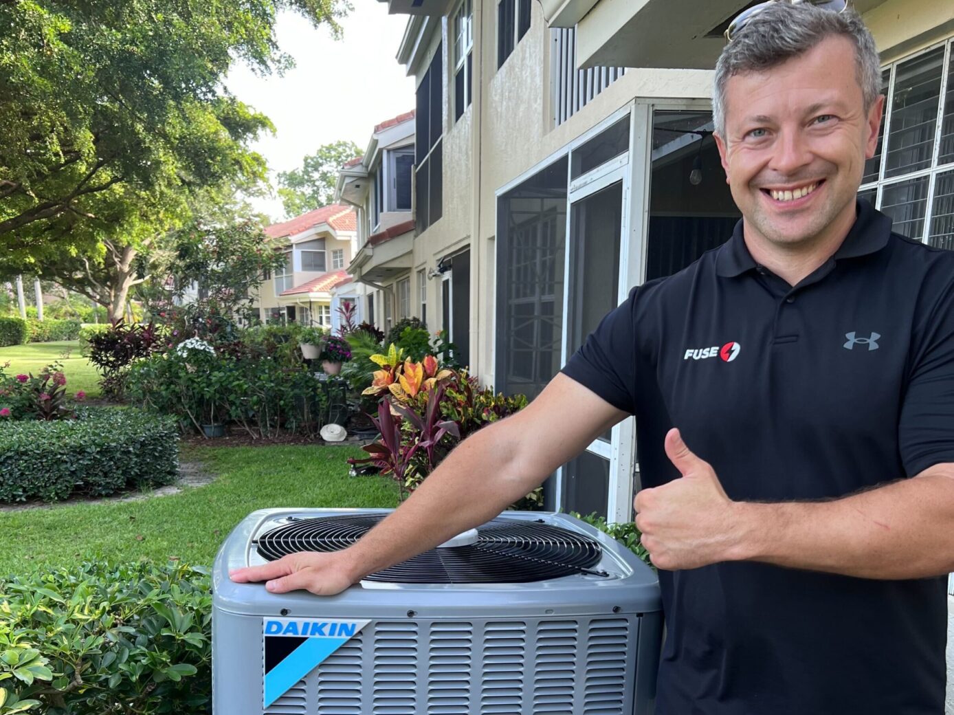 Technician posing next to air conditioning